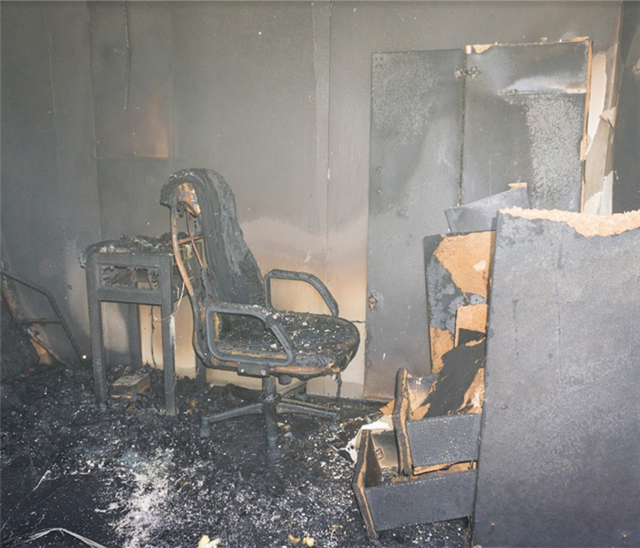 a fire damaged bedroom with soot and debris everywhere